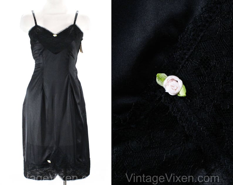 May include: Black slip with lace trim and a small white flower detail. The slip is made of a smooth, silky fabric.