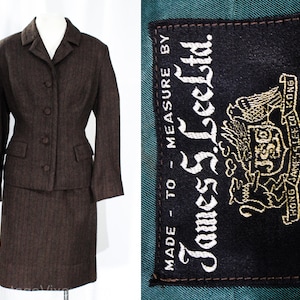 May include: A brown tweed skirt suit with a fitted jacket and a straight skirt. The jacket has a notched collar, a button closure, and two flap pockets. The skirt has a straight silhouette and a zipper closure. The suit has a label that reads "Made to Measure by James S. Lee Ltd. Hand Tailored in Hong Kong."