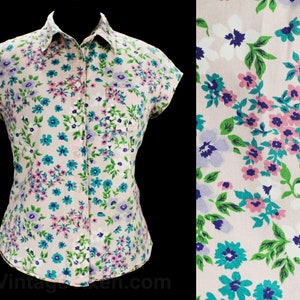 May include: A pink short-sleeved button-down shirt with a floral print featuring pink, blue, green, and white flowers.