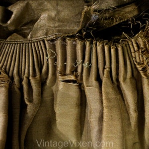 May include: Close-up of a section of vintage fabric in shades of gold and brown. The fabric is heavily textured with pleats and frayed edges, suggesting age and wear. The text "Vintage Vixen.com" is visible at the bottom.
