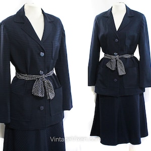 Puede incluir: Un traje de falda azul marino con un cinturón de lunares blancos. La chaqueta tiene un cuello de muesca, dos bolsillos y un cierre de botón. La falda es de línea A y llega hasta la rodilla.