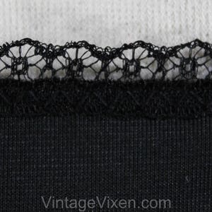 May include: Black fabric with a black lace trim. The fabric has a ribbed texture.