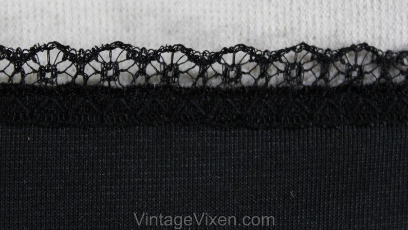 May include: Black fabric with a black lace trim. The fabric has a ribbed texture.