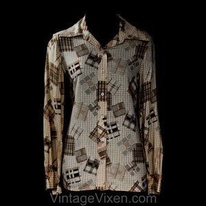 Puede incluir: Una camisa vintage con botones y un diseño de patchwork en tonos marrones, beige y crema. La camisa de manga larga presenta un cuello clásico y puños abotonados. La tela tiene un brillo sutil y el estilo general recuerda a la década de 1970.