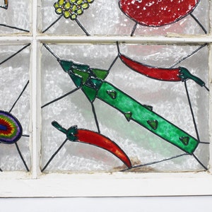 May include: A stained glass window panel featuring a green pepper, red chilli peppers, and a mushroom. The panel is set in a white wooden frame.