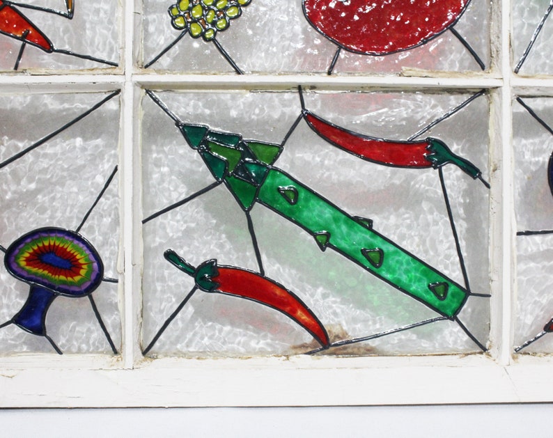 May include: A stained glass window panel featuring a green pepper, red chilli peppers, and a mushroom. The panel is set in a white wooden frame.