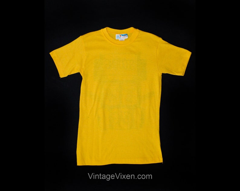 Puede incluir: Una camiseta de manga corta de color amarillo brillante con cuello redondo.