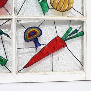 May include: A stained glass window featuring a colourful carrot, mushroom, and other vegetables painted on it.