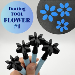 May include: A set of black flower-shaped dotting tools with light blue handles. The image also shows blue flower designs on a dark gray background and a blue circle with the text "Dotting TOOL FLOWER #1".