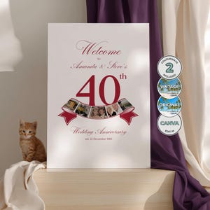 Pode incluir: Uma placa branca de aniversário de casamento com texto bordô que diz: "Bem-vindos ao 40º aniversário de casamento de Amanda e Steve". Inclui fotos e um design de fita. Um pequeno gato tigrado laranja está sentado à esquerda.