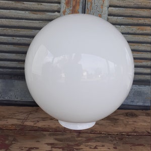 May include: A spherical white glass light fixture globe with a smooth, glossy finish. The orb features a circular opening at the base designed for attachment to a lighting fixture, presenting a clean, uniform appearance with subtle reflections.