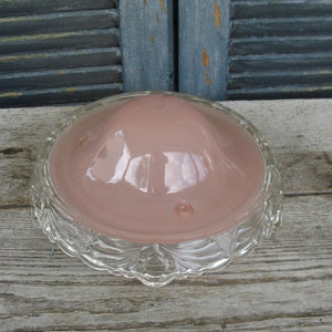 Puede incluir: Una l&aacute;mpara de techo de cristal rosa con un borde festoneado de cristal transparente.