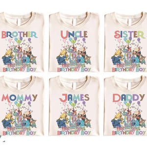 Pode incluir: Seis camisetas creme com gr&aacute;ficos de anivers&aacute;rio. Cada camisa tem uma palavra diferente em letras coloridas: "Brother", "Uncle", "Sister", "Mommy", "James" e "Daddy". As camisas apresentam um design de desenho animado com bolo e bal&otilde;es.