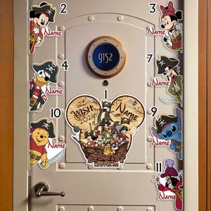 May include: A collection of Disney pirate-themed door magnets featuring Mickey Mouse, Minnie Mouse, Donald Duck, Goofy, Stitch, Winnie the Pooh, and Captain Hook. The central magnet is shaped like Mickey ears with the text Disney WISH 2026 A PIRATE'S LIFE FOR ME.