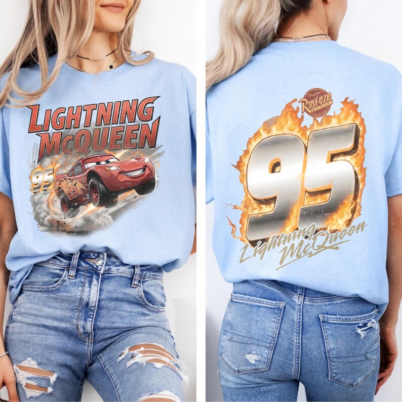 Op de afbeelding: Lichtblauw T-shirt met Lightning McQueen uit de film Cars. De voorkant toont de auto met de tekst "Lightning McQueen" en "95". De achterkant toont "95" in vlammen met de tekst "Lightning McQueen".