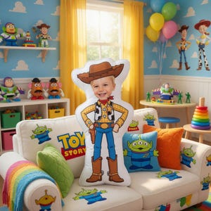 May include: A white sofa with Toy Story alien and character graphics, featuring a large pillow shaped like Woody from Toy Story. The room has a Toy Story theme with character figurines, balloons, and a rainbow blanket.