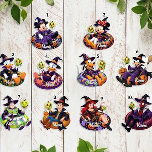 May include: A collection of ten flat acrylic ornaments featuring various cartoon characters dressed as witches and wizards, each holding a green poison apple and sitting on a pumpkin or patterned float, with the word NAME printed on each.
