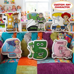 May include: Six custom number-shaped cushions featuring cartoon characters. Number 1 with Woody, 2 with Buzz Lightyear, 3 with Jessie, 4 with Bo Peep, 5 with Rex, and 6 with Hamm. Each cushion displays a name: Mark, Kevin, Alice, Sofia, David, and Sarah.