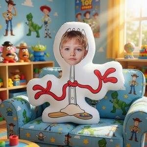 May include: A white plush toy shaped like a character from the movie Toy Story, with a child's face in the center. The toy has red accents and is resting on a blue couch with Toy Story character designs.