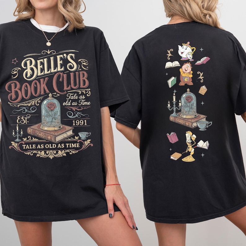 May include: Black t-shirt featuring the text "Belle's Book Club" with a rose in a glass dome graphic. The back of the shirt has a matching design with characters and books. The shirt's design includes the phrase "Tale as old as Time" and the year "1991".