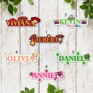 May include: Six custom name stickers featuring Toy Story characters. Designs include Viviana with Jessie, Kevin with Buzz Lightyear, Gilbert with Woody, Olivia with Bo Peep, Daniel with Rex, and Annie with Lotso, each labelled with a number from one to six.