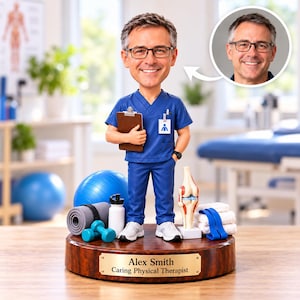 May include: A custom bobblehead of a physical therapist wearing blue scrubs, glasses, and white sneakers. The figure holds a brown clipboard and stands on a wooden base with a plaque reading Alex Smith Caring Physical Therapist.