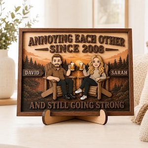 May include: A rectangular wooden wall sign featuring a layered 3D design of a man and woman sitting in chairs, holding beer mugs. The text reads: ANNOYING EACH OTHER SINCE 2008, DAVID, SARAH, AND STILL GOING STRONG. The background shows a sunset landscape.