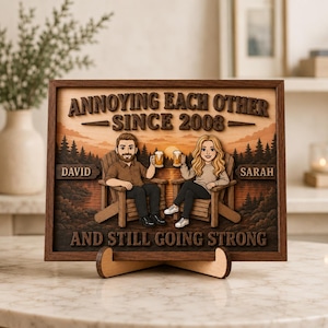 May include: A rectangular wooden wall art piece featuring a layered design of two people sitting in chairs holding beer mugs. The text reads ANNOYING EACH OTHER SINCE 2008, DAVID, SARAH, and AND STILL GOING STRONG against a sunset forest background.