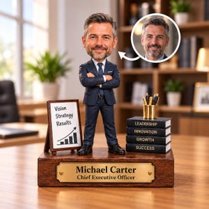 Puede incluir: Una figura bobblehead personalizada de un hombre con traje azul marino y brazos cruzados, sobre una base de madera con una placa dorada Michael Carter Chief Executive Officer. Incluye una pequeña pizarra con el texto Vision Strategy Results.