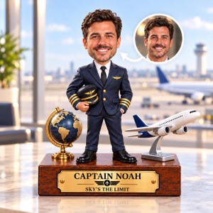 Könnte beinhalten: Eine personalisierte Wackelkopf-Figur eines Piloten in dunkelblauer Uniform mit Mütze auf einem Holzsockel, der die Aufschrift CAPTAIN NOAH SKY'S THE LIMIT trägt. Daneben stehen ein kleiner Globus und ein Modellflugzeug auf einem Ständer.