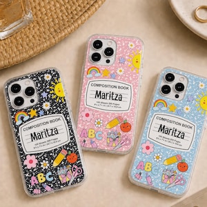May include: Three smartphone cases featuring a composition book design with the name Maritza, 100 sheets 200 pages, and 9.75 in x 7.5 in / 24.7 cm x 19.0 cm printed on the label. The cases are black, pink, and light blue with colorful icons.