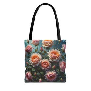 Könnte beinhalten: Tragetasche mit einem Blumendesign aus rosa und pfirsichfarbenen Rosen auf türkisblauem Hintergrund. Die Tasche hat einen schwarzen Griff und besteht aus strapazierfähigem Stoff. Die Rosen blühen voll, mit grünen Blättern und Stielen.