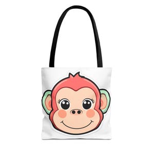 Könnte beinhalten: Weiße Tragetasche mit einem Cartoon-Affen-Gesicht. Der Affe hat einen rosa Kopf, pfirsichfarbene Wangen und große Augen. Die Tasche hat schwarze Griffe und ist zum Tragen von Gegenständen konzipiert.