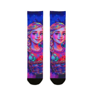 Könnte beinhalten: Ein Paar Socken mit einer lebendigen Illustration eines Mädchens mit blonden Zöpfen, das einen Korb mit roten Äpfeln hält. Das Kunstwerk ist in einem farbenfrohen Neonstil vor einem dunkelblauen Hintergrund gehalten und schafft ein skurriles Design.