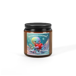 Könnte beinhalten: Ein braunes Glas mit schwarzem Deckel. Das Glas hat ein Etikett mit einem Cartoon-Oktopus, der ein rotes Herz hält. Der Oktopus ist regenbogenfarben. Auf dem Etikett steht: "Don't hold on to everything...sometimes an armful of love is enough."