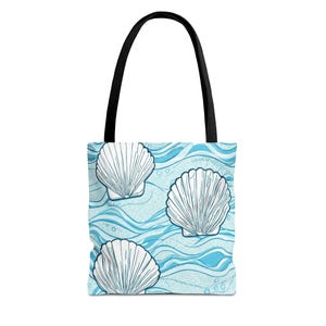 Könnte beinhalten: Eine Tragetasche mit schwarzem Griff und einem hellblauen und weißen Muscheldesign. Die Tasche zeigt drei große weiße Muscheln auf einem Hintergrund aus blauen Wellen und kleinen Blasen. Die Tasche ist zum Tragen von Gegenständen konzipiert.