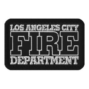 May include: A rectangular black patch with white embroidered text. The text reads "LOS ANGELES CITY FIRE DEPARTMENT" in a bold, blocky font. The patch has a black border.