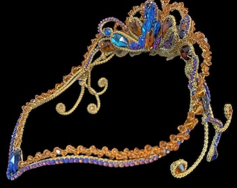 May include: A decorative headpiece crafted from gold-toned wire, featuring an intricate arrangement of amber, blue, and purple faceted crystals. The design includes swirling wire accents and a central elevated peak adorned with various gemstone shapes.