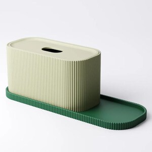 May include: A tissue box with a ribbed, light green exterior and a matching lid. The box sits on a dark green tray with a ribbed edge. The design is modern and minimalist.