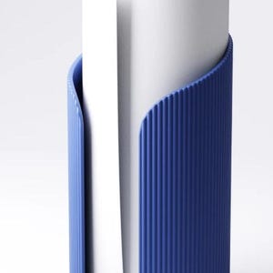 May include: A white paper roll is held by a blue holder. The holder has a ribbed texture and a curved design that wraps around the paper roll. The holder is made of a solid, opaque material.