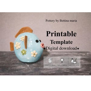 Puede incluir: Una figura de pez de cerámica azul claro con aletas y cola naranjas, y detalles florales blancos y verdes. El pez tiene ojos negros y boca rosa. El texto en la imagen dice "Printable Template Digital download".