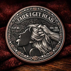 May include: A two-tone coin with the text "TAILS I GET HEAD" and "FLIP ME. FEEL THE LUCK." The coin depicts a woman's profile with her tongue out and a hand holding her hair. The coin is decorated with floral and heart motifs around the edge.