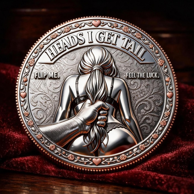 May include: A silver coin with a detailed relief design. The coin features the text "HEADS I GET TAIL" and "FLIP ME. FEEL THE LUCK." The central image depicts a person from the back, with a hand holding their hair. The coin has a decorative border.