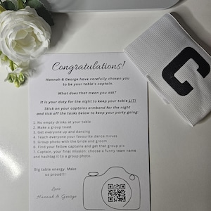 May include: A wedding table captain's invitation with the text "Congratulations!" and a list of tasks. A white armband with a black "C" and a white rose are also visible. The invitation is from Hannah & George.