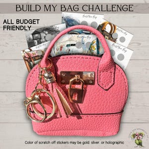 May include: A pink purse-shaped keychain with gold hardware and a lock closure. The keychain holds several scratch-off cards with the text "Build Your Bag". The text "Build My Bag Challenge" and "All Budget Friendly" are also visible.