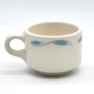 Taza de café plana vintage "Hoja de roble" de Homer Laughlin China Company, "La mejor porcelana" para restaurantes; motivo de hojas turquesas y grises.