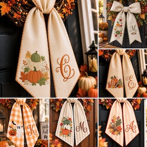 May include: A collection of decorative fabric door bows featuring various autumn-themed embroidery designs including pumpkins, acorns, and ghosts, paired with personalized monogram letters in script font on cream, plaid, or striped fabric ribbons.