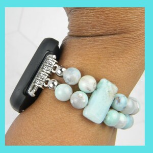 May include: A light blue beaded watch band with silver clasps. The band is made of round and rectangular beads.