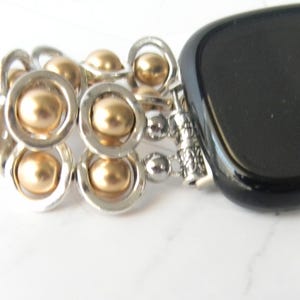 May include: A black onyx stone bracelet with a silver chain and gold beads.