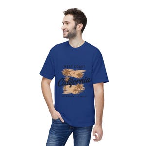 May include: A royal blue t-shirt with a graphic design. The design features the text "West Coast California" and palm trees. The text "Santa Monica, Los Angeles" is also included. The shirt is made of a soft material.
